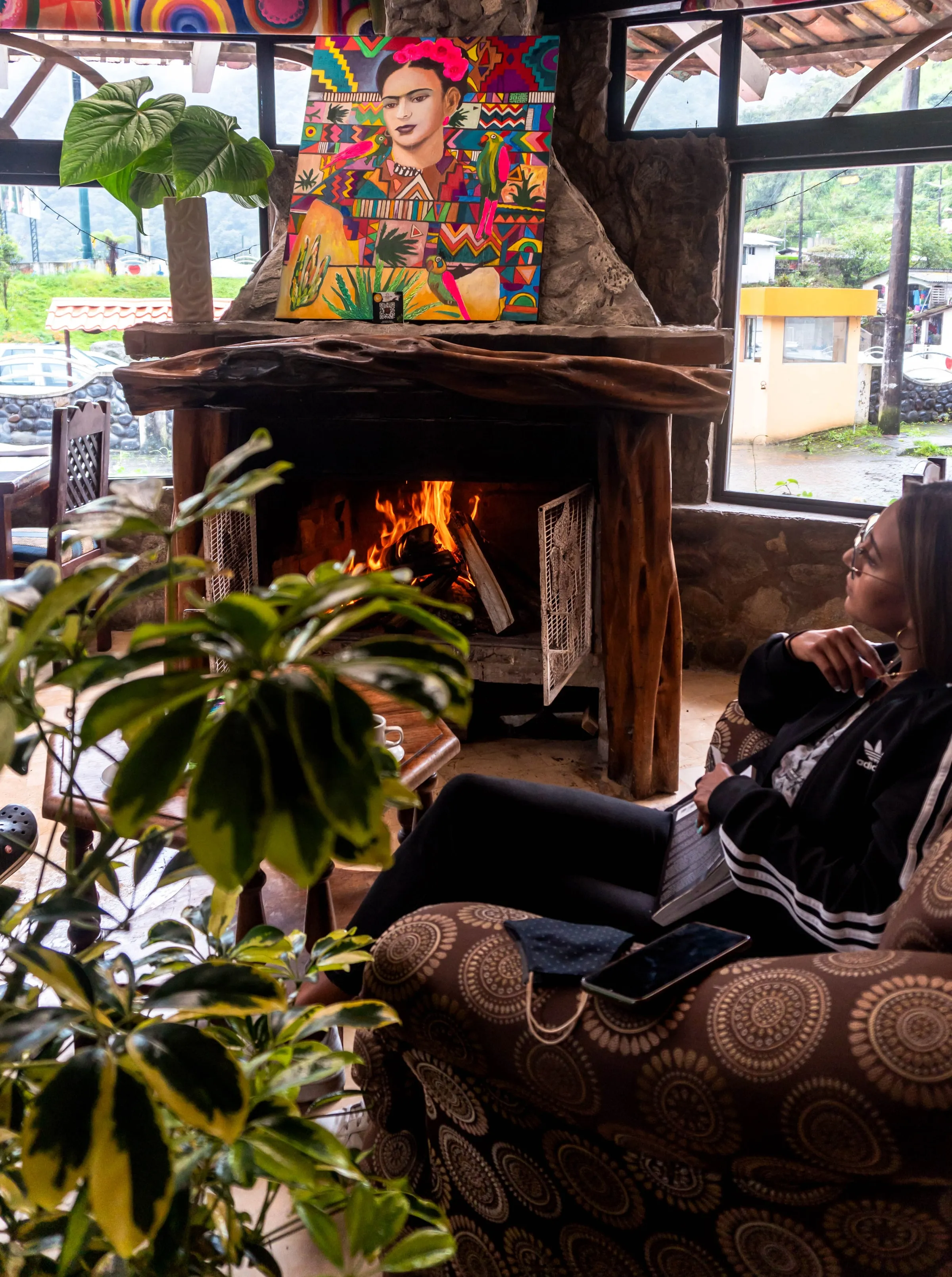Sala con chimenea encendida y pintura artesanal en Hotel Spa Miramelindo, un rincón para leer o conversar