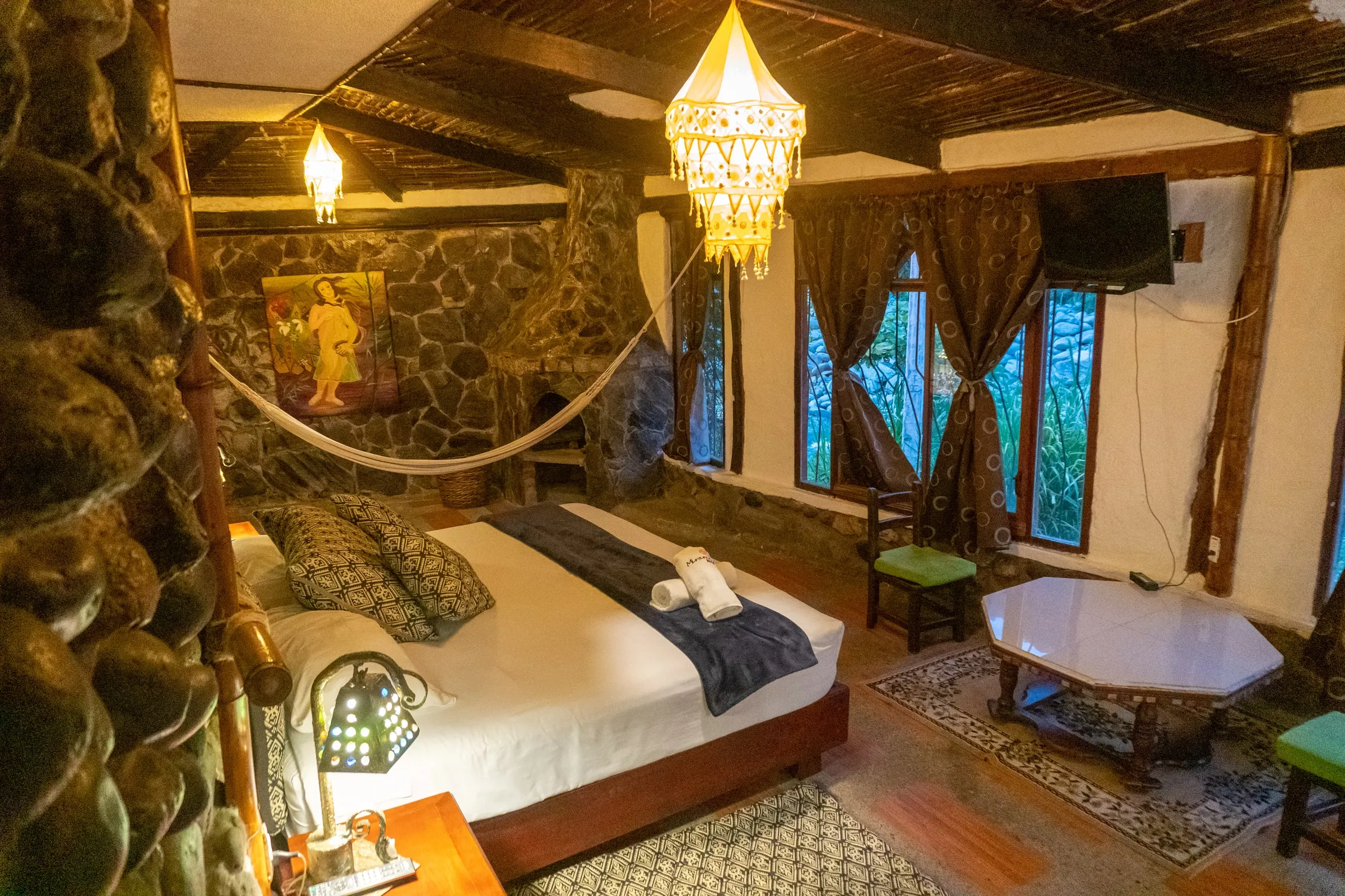 Habitación de Hotel Spa Miramelindo con hamaca, pintura artesanal y paredes de piedra