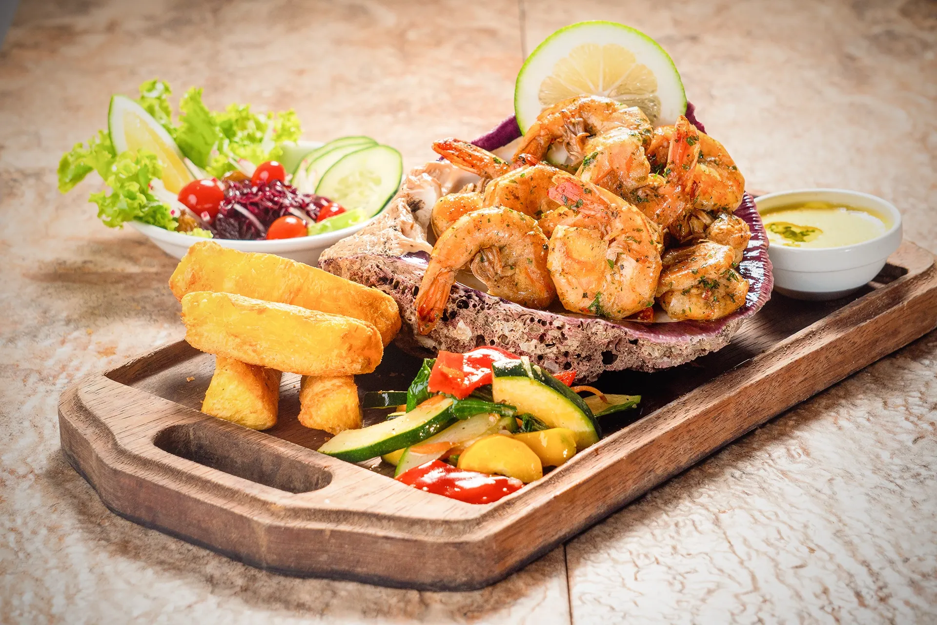 Plato de camarones grillados con patacones, ensalada y salsas, servido en tabla de madera en el restaurante de Hotel Spa Miramelindo